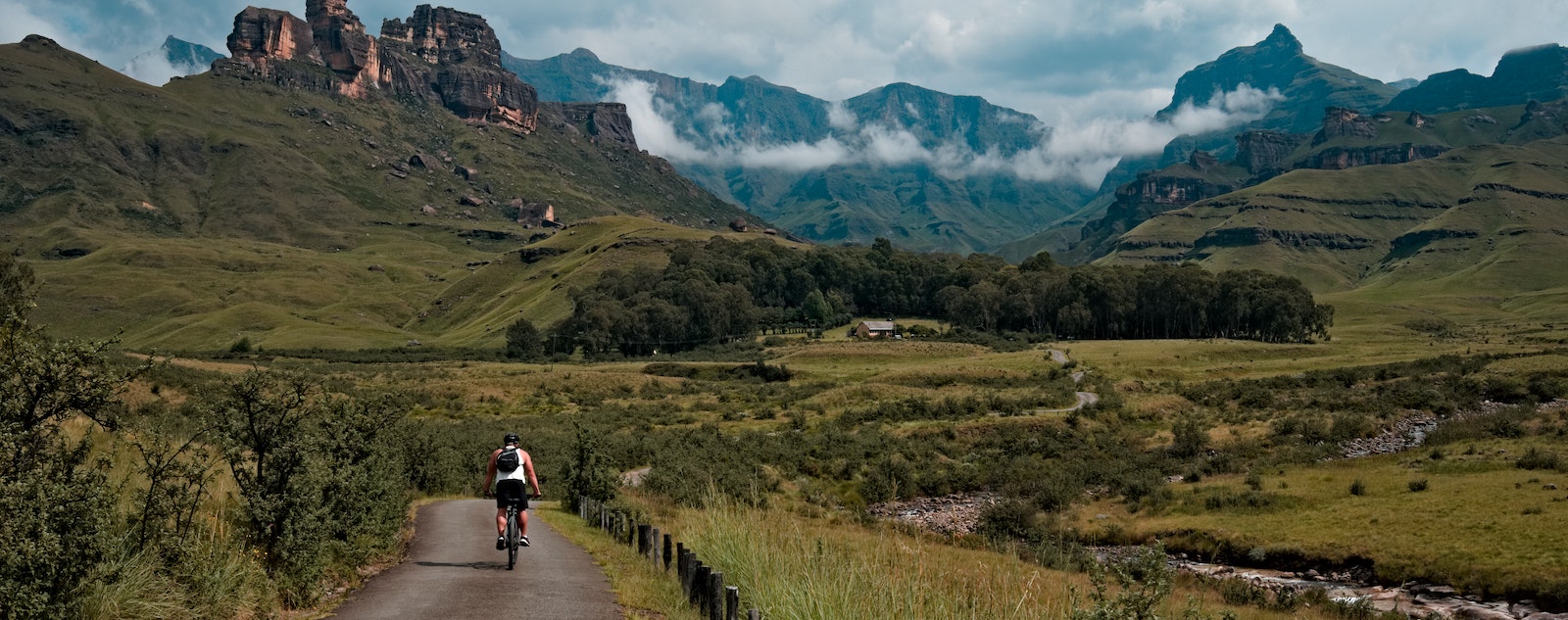 a man riding a bicycle in a mountain valley